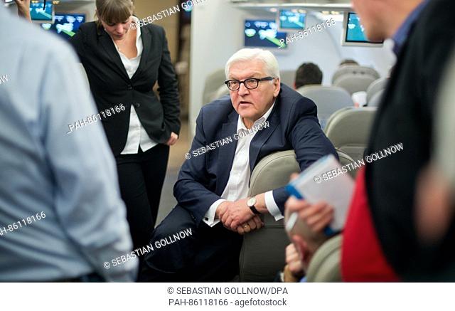 The German Federal Foreign Minister Frank-Walter Steinmeier (M) speaks to journalists on his plane ride headed to Berlin after his meeting with the Foreign...