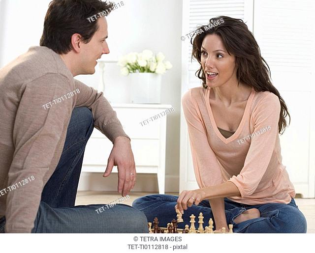 Couple talking and playing chess