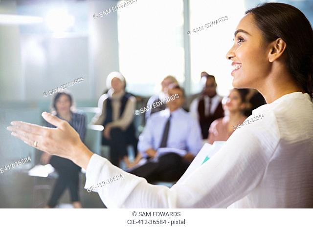 Smiling businesswoman leading conference presentation