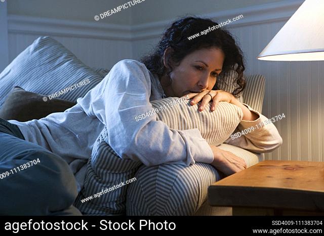 Worried Caucasian woman sitting on sofa
