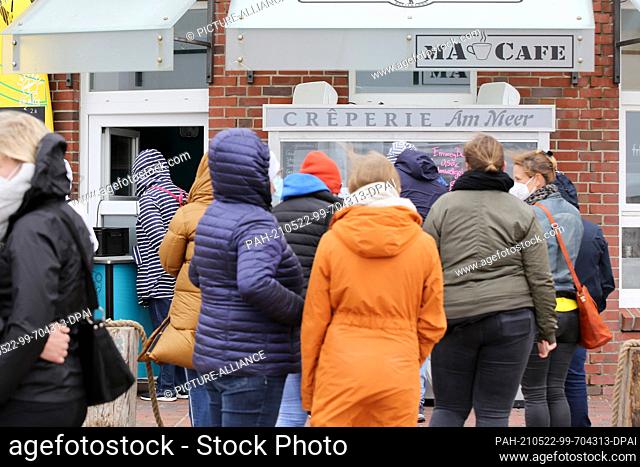 22 May 2021, Schleswig-Holstein, Westerland: Sylt holidaymakers queue at a creperie on the Westerland beach promenade. The tourist resorts in Schleswig-Holstein...