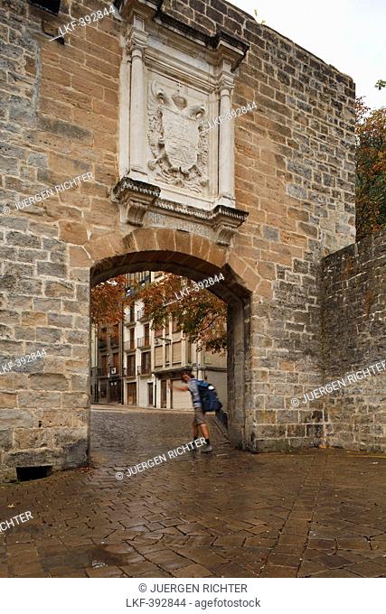 Pilgrim in front of Portal a Francia, town gate at the old town, Pamplona, Camino Frances, Way of St. James, Camino de Santiago, pilgrims way