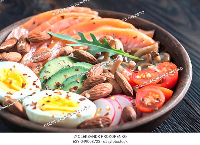 Healthy bowl with salmon, avocado, egg and vegs