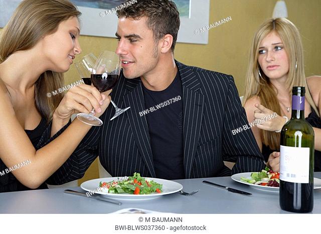 young couple drinking red vine, blond woman watching envious