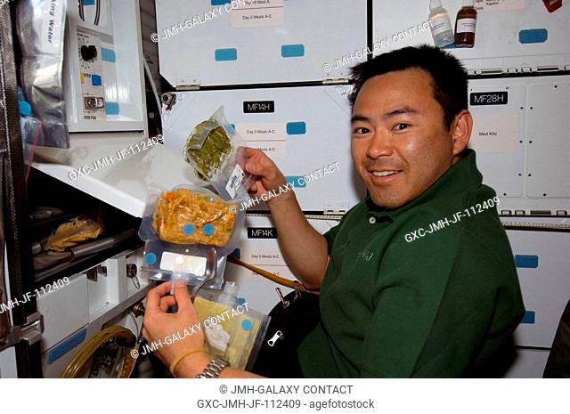 Japan Aerospace Exploration Agency (JAXA) astronaut Akihiko Hoshide, STS-124 mission specialist, prepares to eat a meal at the galley on the middeck of Space...
