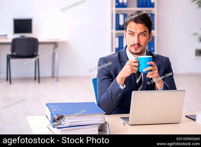 Young businessman employee drinking coffee during break