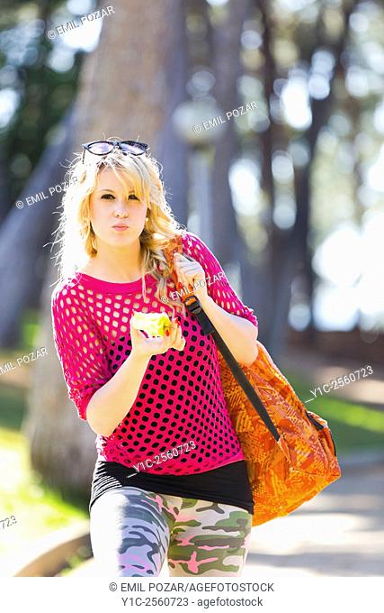 Young woman on vacation eating apple