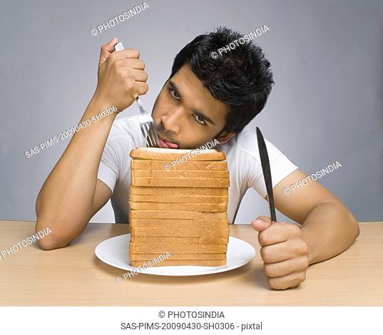 Man licking lips in front of slices of bread