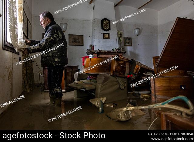 18 May 2023, Italy, Faenza: Local resident Guiseppe Beltrame stands in his living room after it has been devastated by a meters-high flood wave
