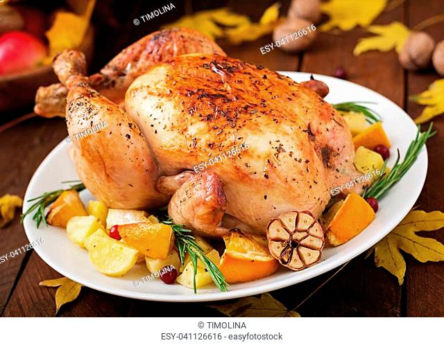 Roasted turkey garnished with cranberries on a rustic style table decorated with pumpkins, orange, apples and autumn leaf. Thanksgiving Day