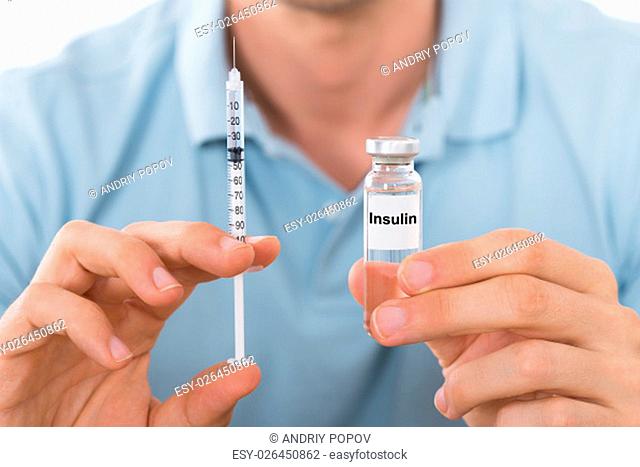Close-up Of Young Man Holding Insulin And Syringe