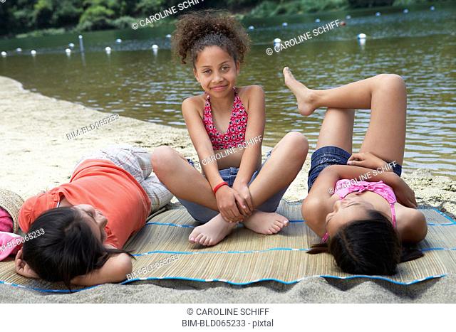 Young girl friends relaxing near lake