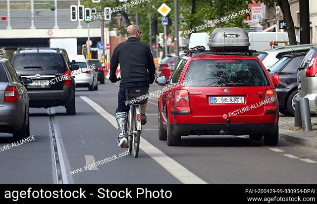 29 April 2020, Berlin: A passenger car is parked on a cycle path in the Köpenick district and obstructs cyclists who have to avoid the vehicle