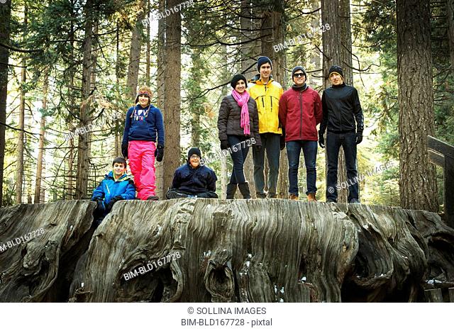 Family standing on enormous stump in forest