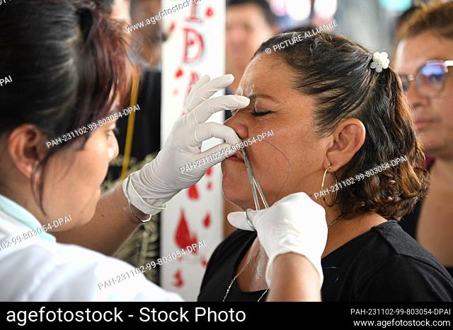 02 November 2023, Mexico, Huixtla: Diana Vargas from El Salvador has her lips sewn shut during a protest. In the municipality of Huixtla, Chiapas