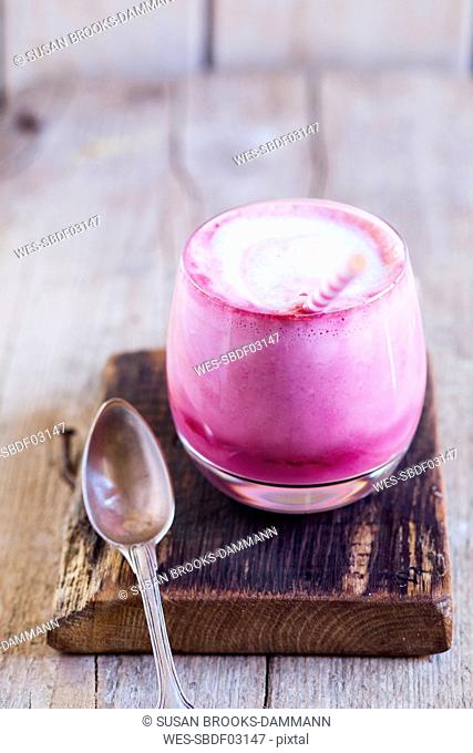 Glass of pink latte with beetroot juice, plant milk, ginger and rice syrup