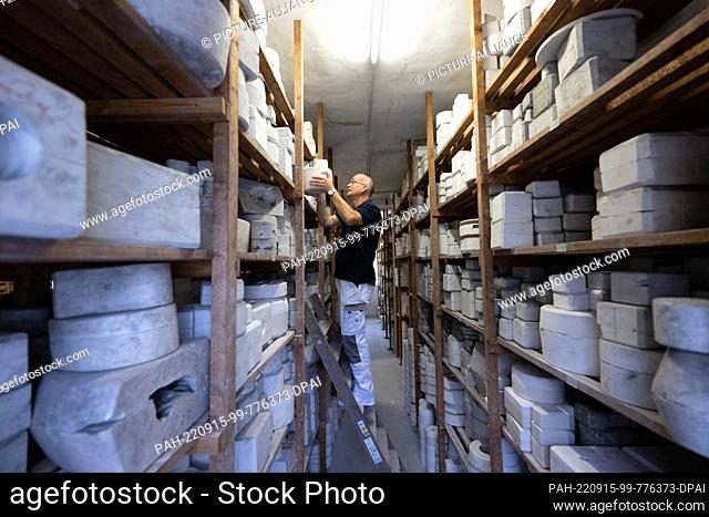 15 September 2022, Saxony, Meißen: Sven Beyer, head of mold making, stands on a ladder in the mold archive of the Meissen porcelain manufactory