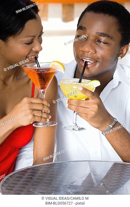 Multi-ethnic couple drinking cocktails