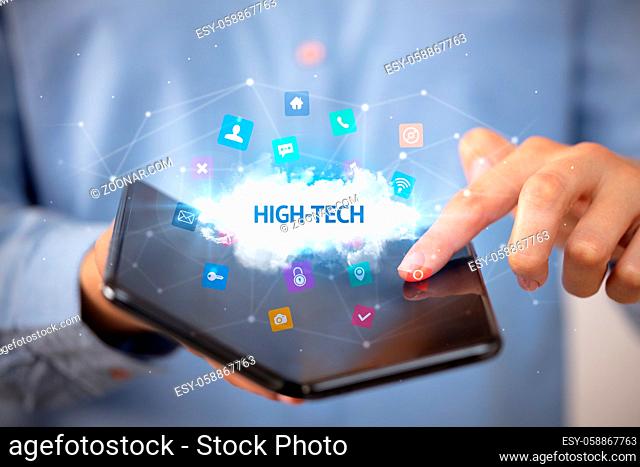 Businessman holding a foldable smartphone with HIGH-TECH inscription, technology concept