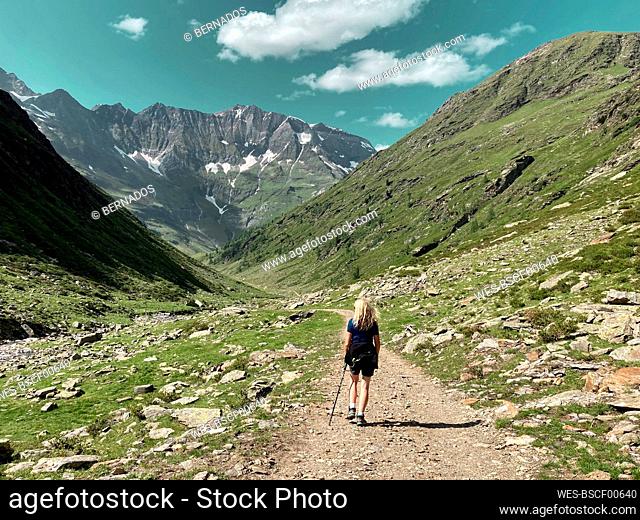 Female hiker following trail at Gruppo Di Tessa Nature Park in Val Venosta during summer