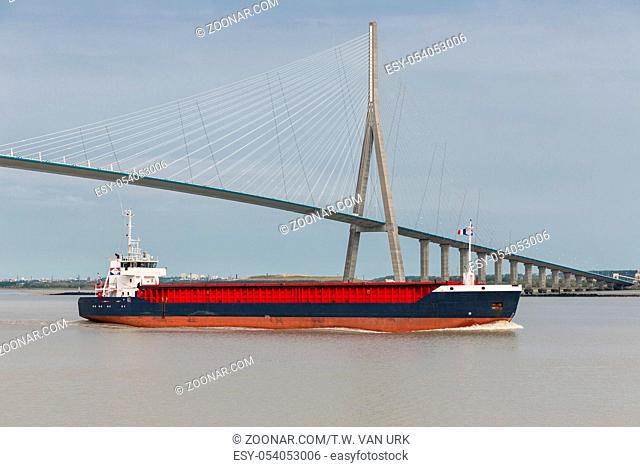 Cargo ship passing Pont de Normandie over river Seine in France