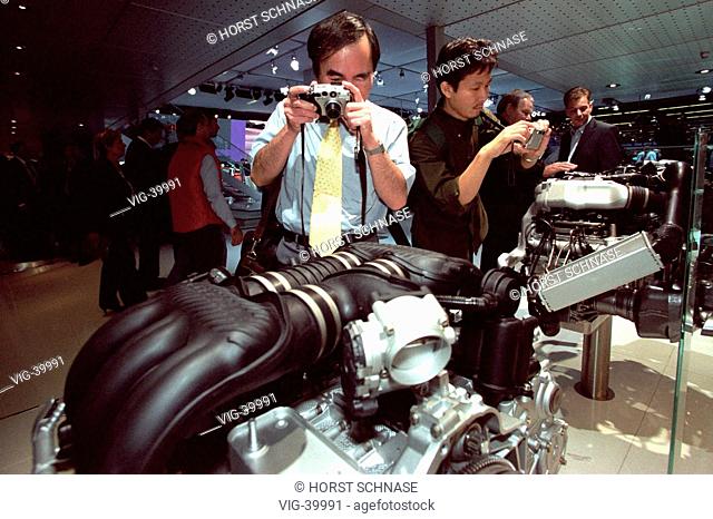 60th international motor show passenger cars ( IAA ): Asian visitors taking photos of car engines. - FRANKFURT, GERMANY, 10/09/2003
