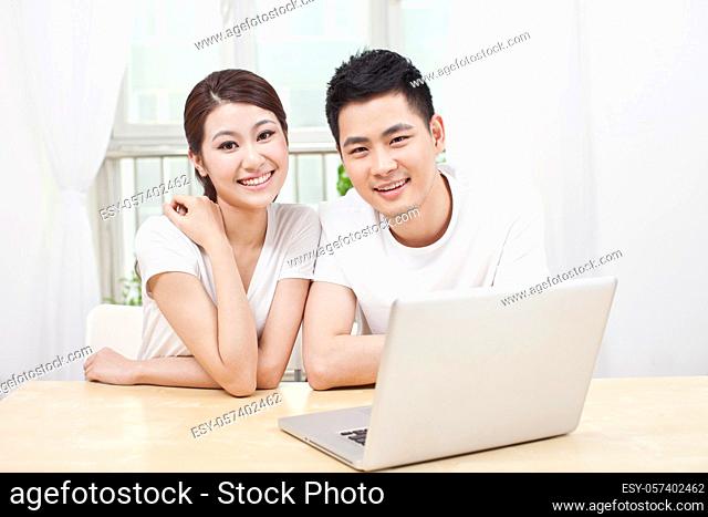 A young Couple Using Laptop at Home high quality photo