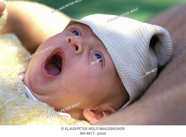 Eight-week-old Baby with cap yawning MR