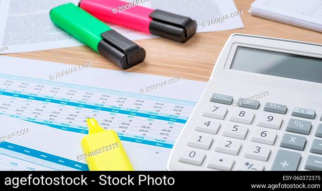 A desk with financial documents and Highlighters