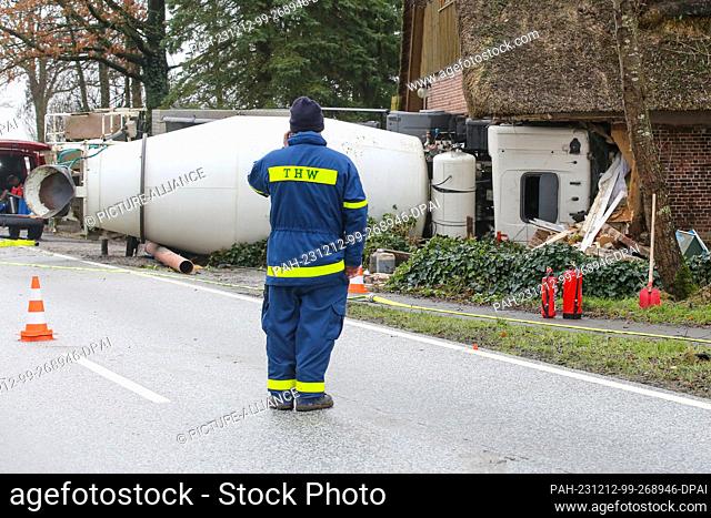 12 December 2023, Schleswig-Holstein, Blomesche Wildnis: Emergency services stand next to a concrete mixer that has crashed into a house