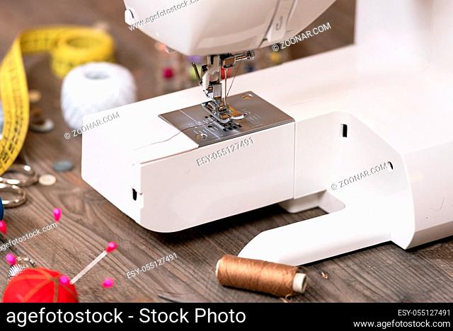 Seamstress or tailor background with sewing tools, colorful threads, sewing machine and accesories