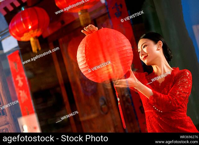 The young woman hangs red lanterns
