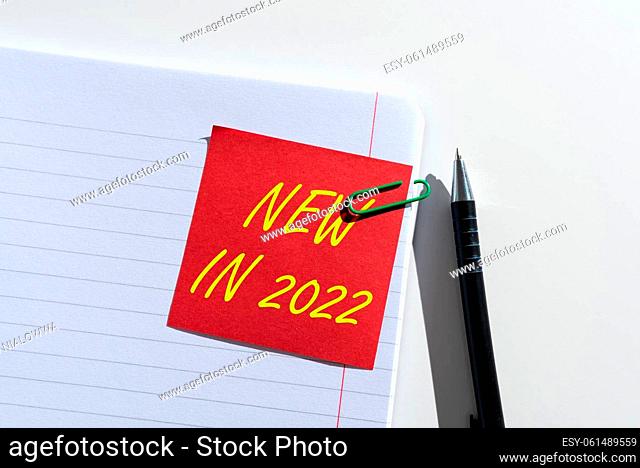 Handwriting text New In 2022, Business concept list of fresh things got introduced this year or the next Sticky Note With Important Idea Clipped On Opened...