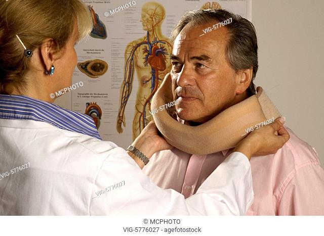 Eine Aerztin legt einem aelteren Mann eine Halskrause an, MR, 2007| A lady doctor put a neckfrill on the neck from a old man - Hamburg, Hamburg, Germany