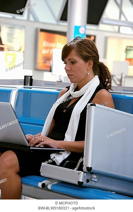Young female entrepreneur sits at the airport with her PC