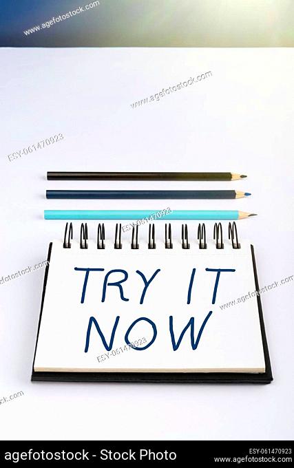 Hand writing sign Try It Now, Business concept Free trial of something new experiment different things Important Informations Written On Notebook Next To...