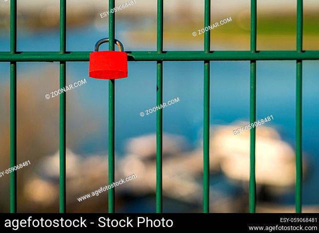 Love lock and grid of the lift bridge Walsum in Duisburg, North Rhine-Westphalia, Germany - with some blurry boats in the background