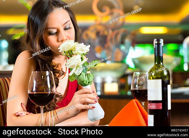 Chinese nervous, hoping, lonely, dreamy, heartsick woman in a restaurant waiting for a date got stood up