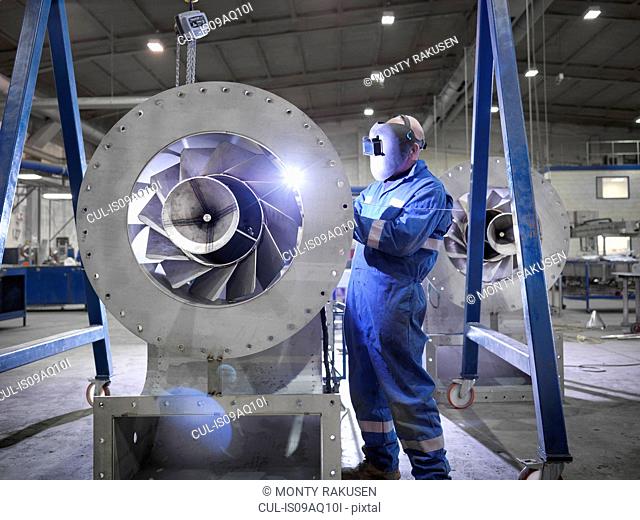 Engineer welding airduct part in engineering factory