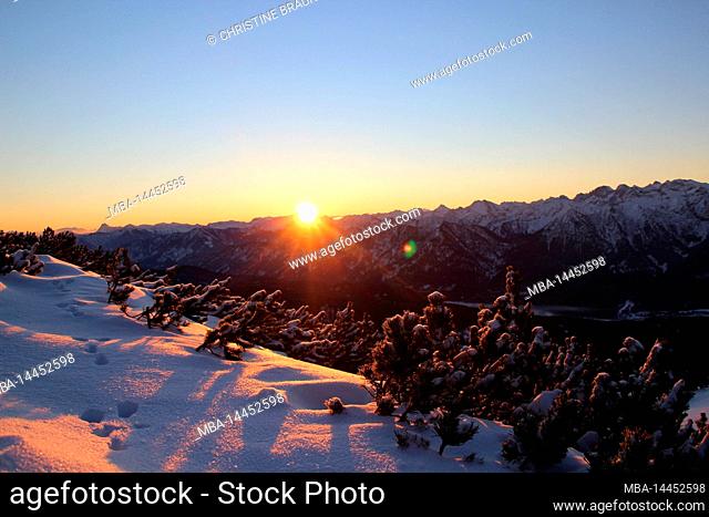 Sunrise during winter hike through the mountain forest to Simetsberg. Back light, path, Germany, Bavaria, Walchensee, Einsiedl