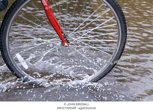 Cyclist drives bike through flooded street after torrential rain caused flooding in Oxford and the Thames Valley area, July 2007