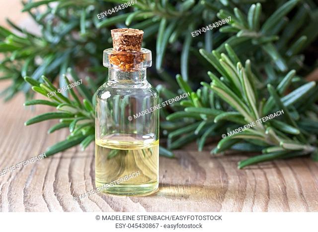 A bottle of essential oil with fresh rosemary in the background