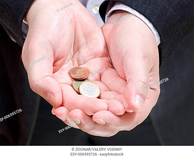 pile of coins in businessman's handful