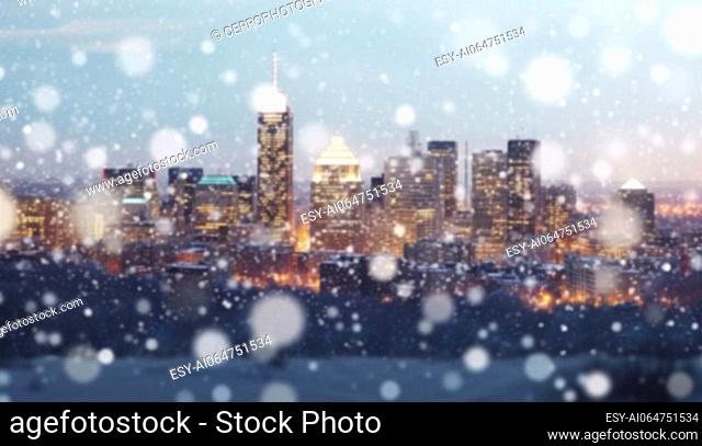 Magical winter snow fall and city lights. blurred background city street with Christmas illuminations, blurred holiday background