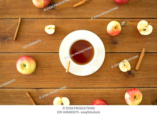 cup of tea with apples and cinnamon on table