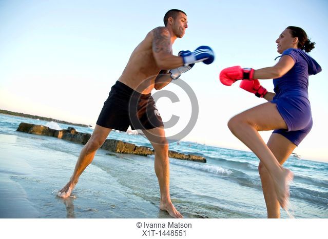 Couple kickboxing on the beach