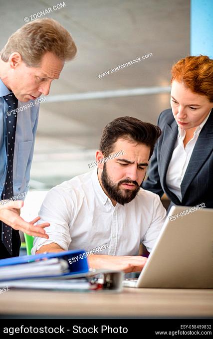 Mobbing, stress, work, scandal concepts. Angry bosses man and woman screaming and shouting at their worker while he is working on laptop computer