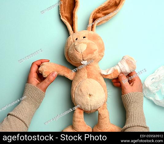 soft plush rabbit with a bandaged paw with a white medical bandage, trauma