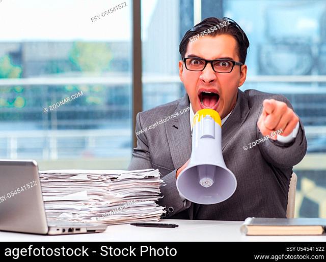 The angry businessman with loudspeaker in the office