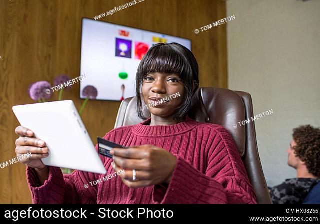 Portrait young woman online shopping with digital tablet and credit card